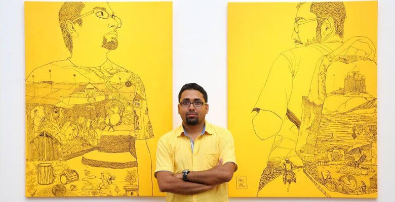 Melvin Thambi standing in front of his work at an exhibit.