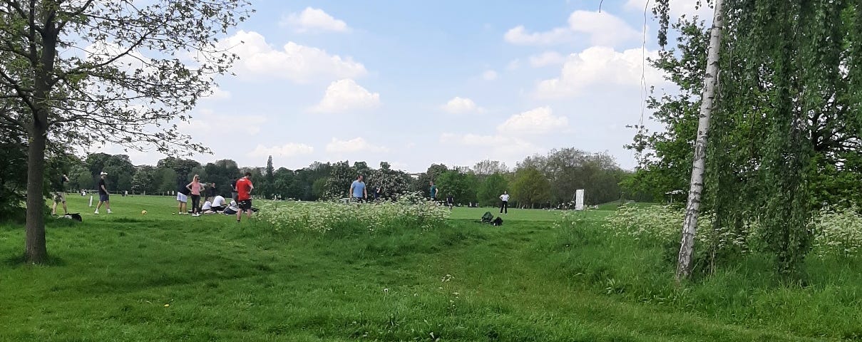 a group of people playing in the Regent’s Park on a nice, sunny day