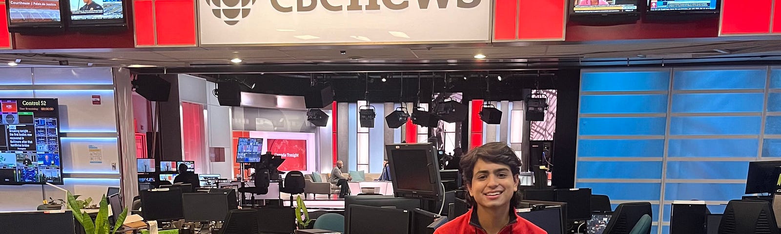 Luis sitting on a desk in the CBC newsroom