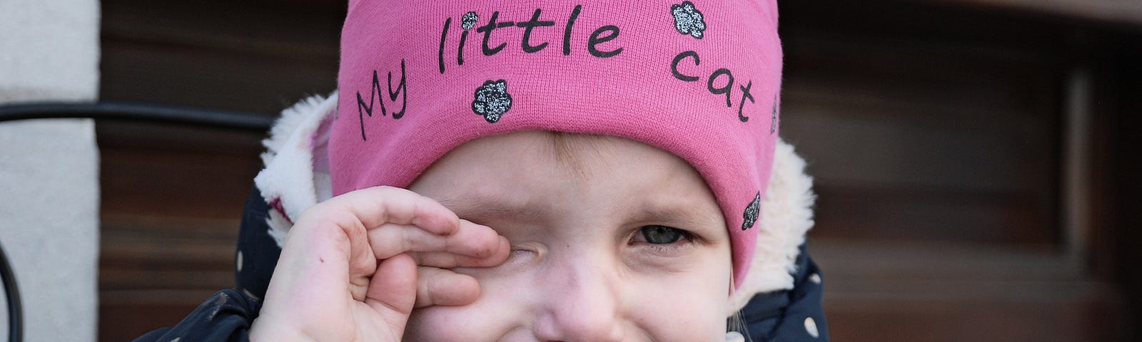 Crying girl wearing a pink hat