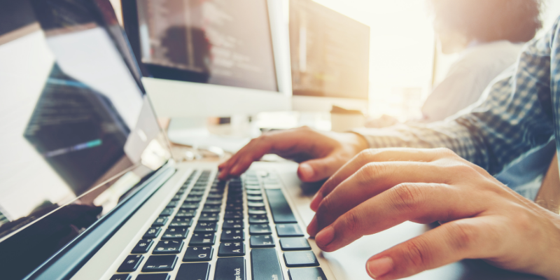 Man typing on computer keyboard for my article on How I Went From $0 to Over $1,000 on Fiverr