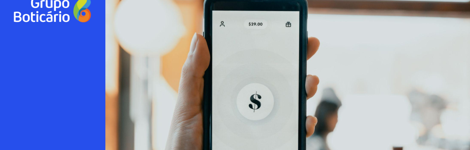 Uma mão segurando um celular com cifra de dólares na tela
