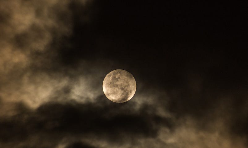Moon partially obscured by clouds