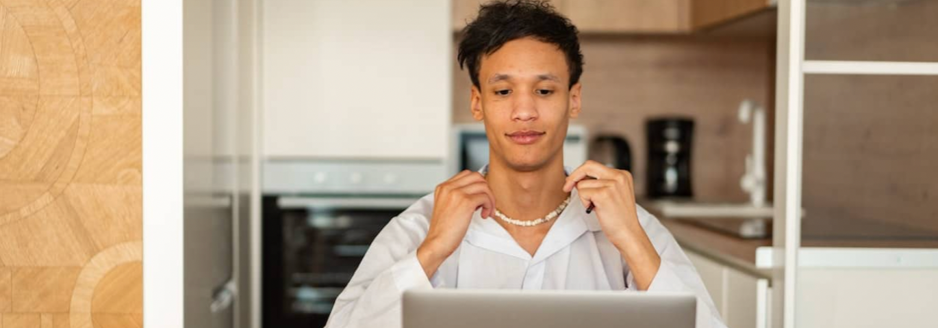 a person in a white shirt sitting at a table with a book and a laptop in front of them, figuring out how to know if they are ready for a career change