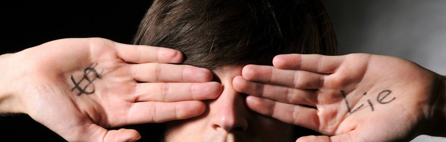 Man covering eyes with hands. One hand has a dollar sign and the other says, lie.
