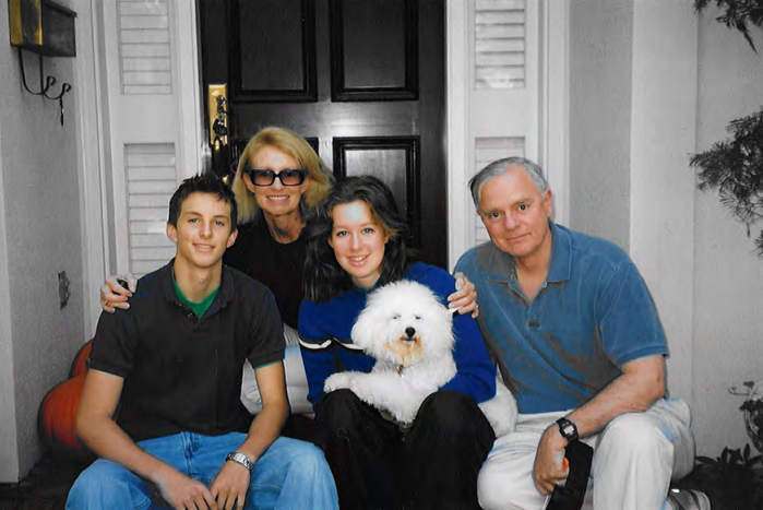 Elizabeth Homes with her mother, bother and father. She is holding a beautiful whitle dog.