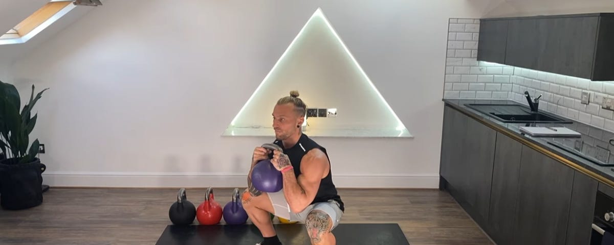 White male demonstrating Kettlebell Squats exercise