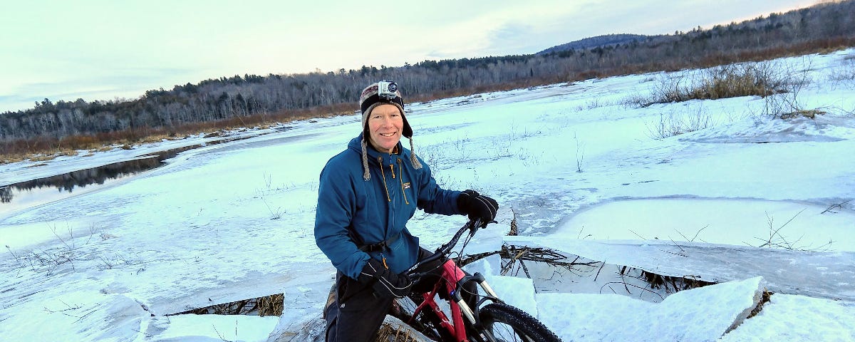 A man riding a bike with studded tires has broken through the ice.