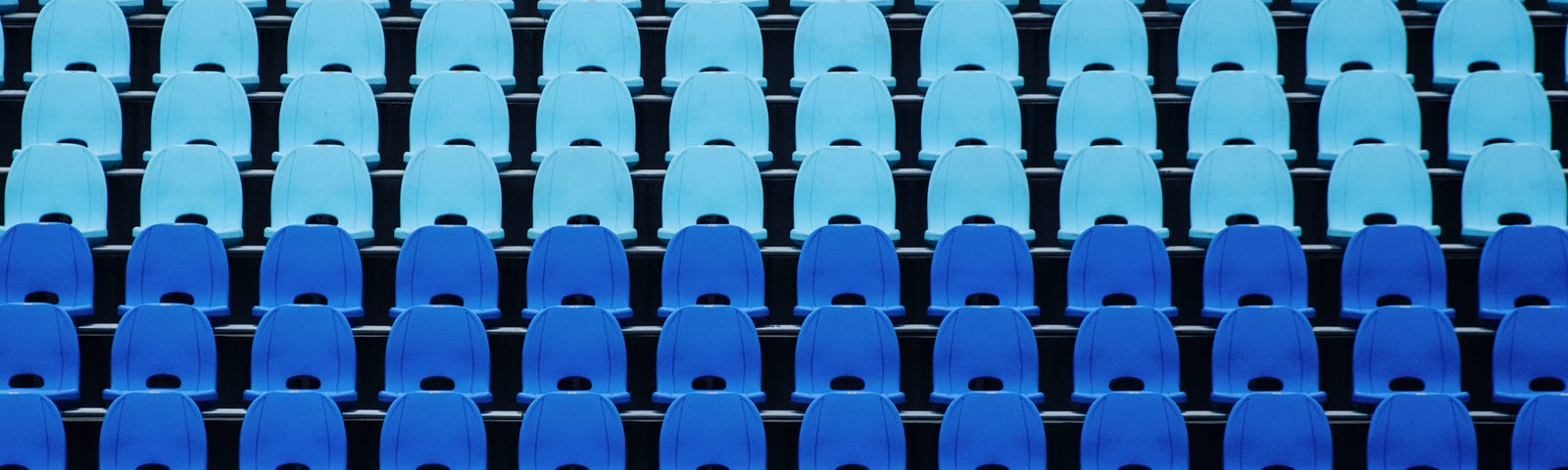 Image of multiple rows of empty blue stadium seats