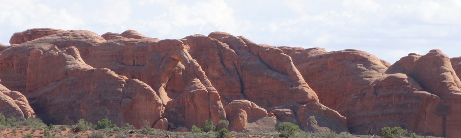 A stunning rock ridge with an arch poking out in Arches National Park. Jeep ride in Arches, National Parks, Utah, Nevada, travel, vacation