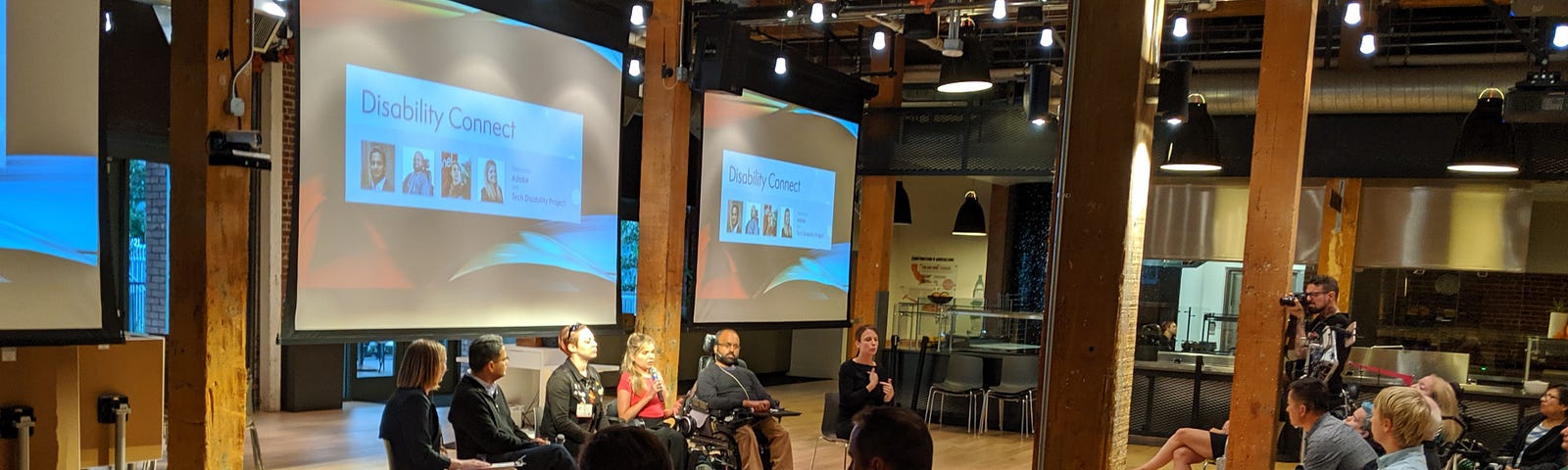 4 panelists, a moderator, and an ASL interpreter sit in front of an audience during Disability Connect at Adobe SF.