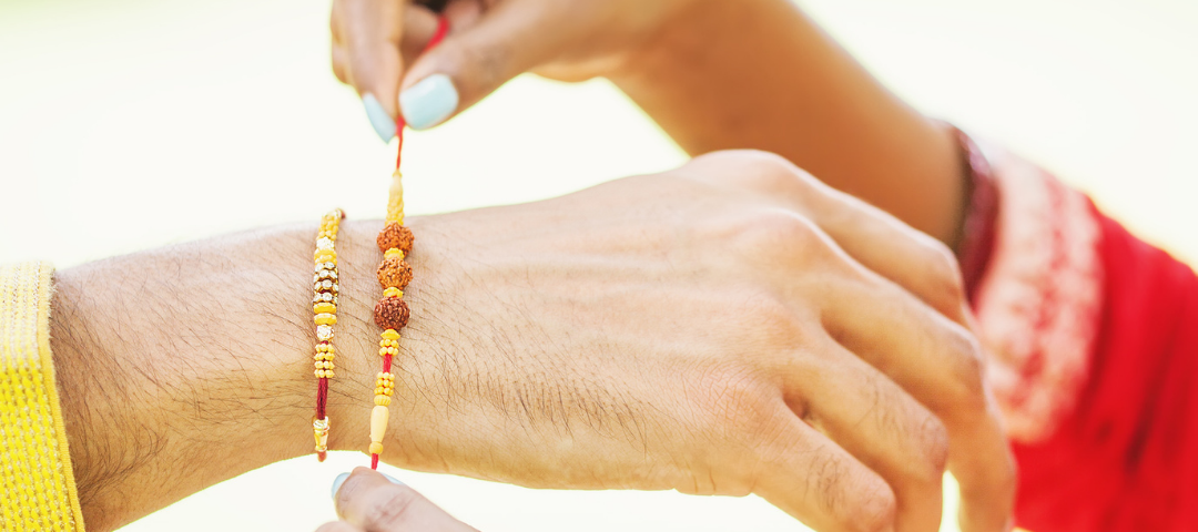 A sister trying a beautiful band on her brothers wrist