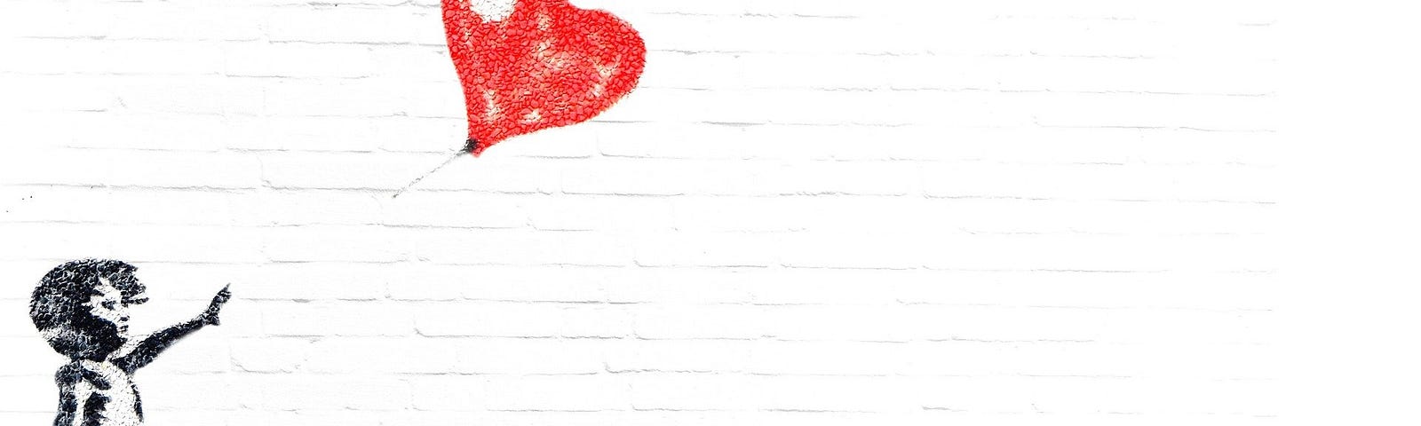 Little girl releasing a red heart-shaped balloon.