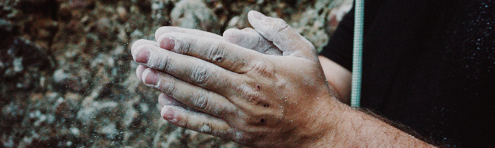 Rock climber’s hands cover with chalk.