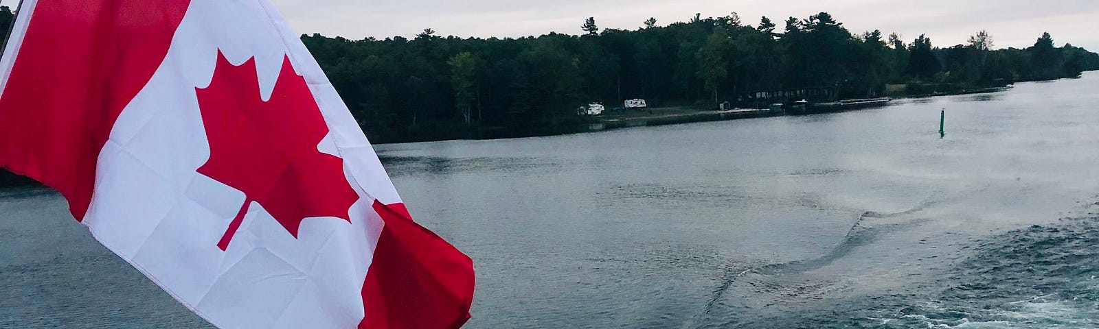 Photo of a Canadian flag with boat rails on a lake