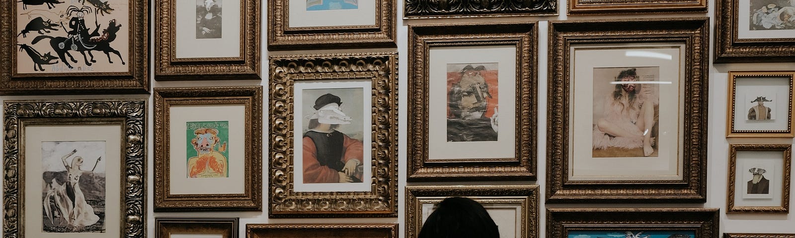 woman looking at several small-framed piece of art in an art gallery