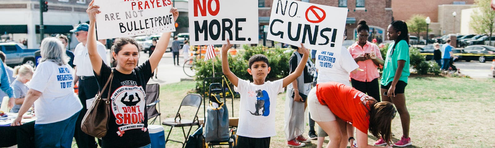 School kids and parents hold protest signs in favor of gun control. Photo by Heather Mount on Unsplash