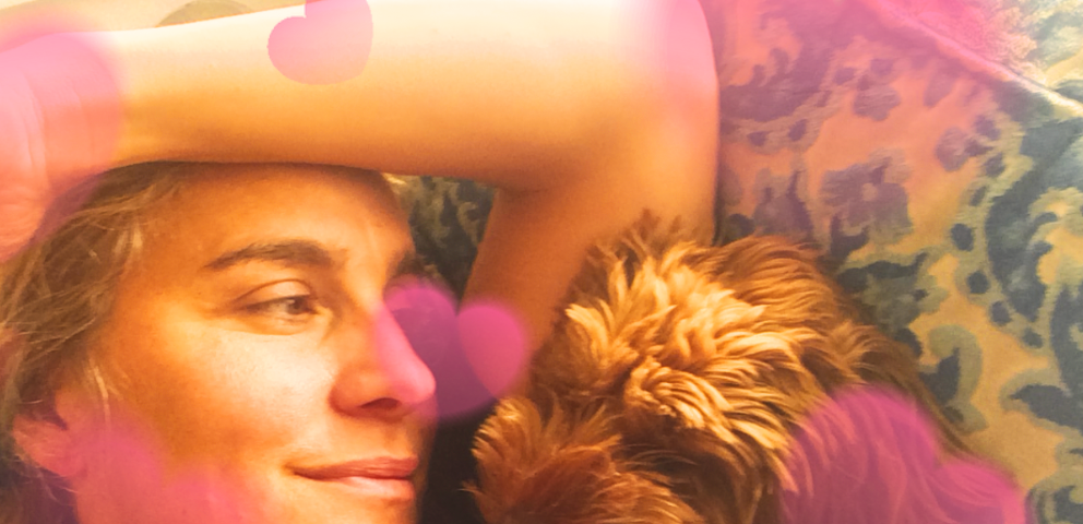 photo of author and dog on couch cuddling, surrounded by hearts
