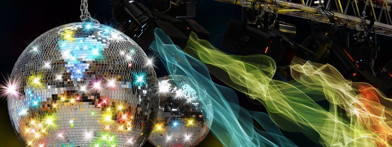 Mirror balls hanging and refracting coloured lights, disco lighting