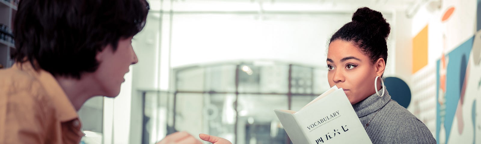 Woman reads nonfiction book and discusses with man