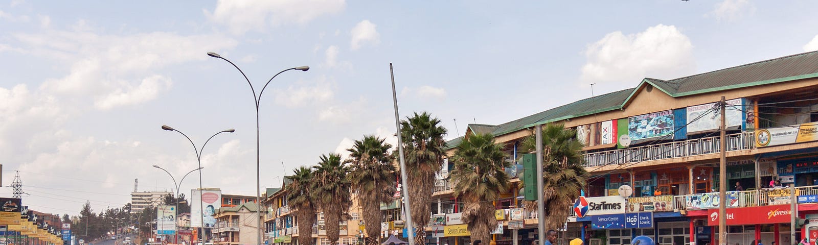 Two motorcycles cross a busy intersection in Kigali, Rwanda