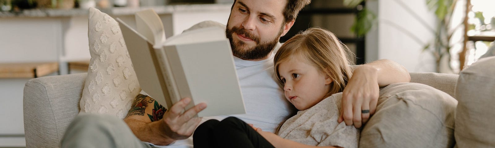 A father reading to his young daughter.