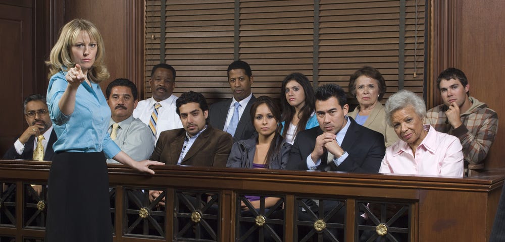 Portrait of a female advocate pointing with jurors sitting together in the witness stand at court house