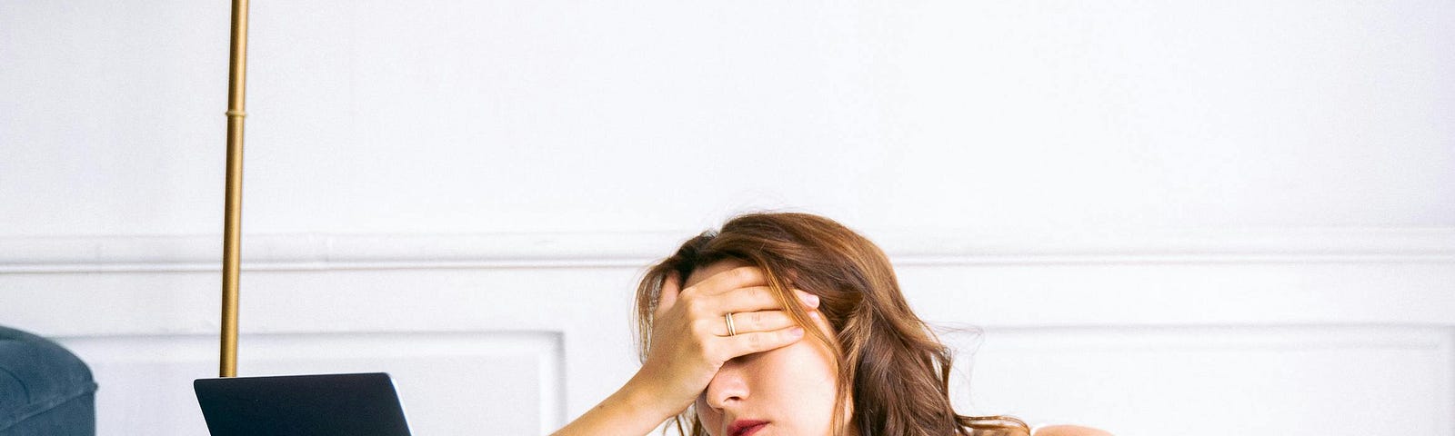 Woman in White Spaghetti Strap Top and Blue Shorts Sitting on Floor Feeling Exhausted