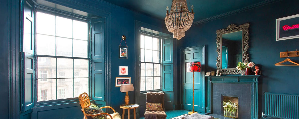 A wood-paneled bedroom painted in various shades of deep blue.