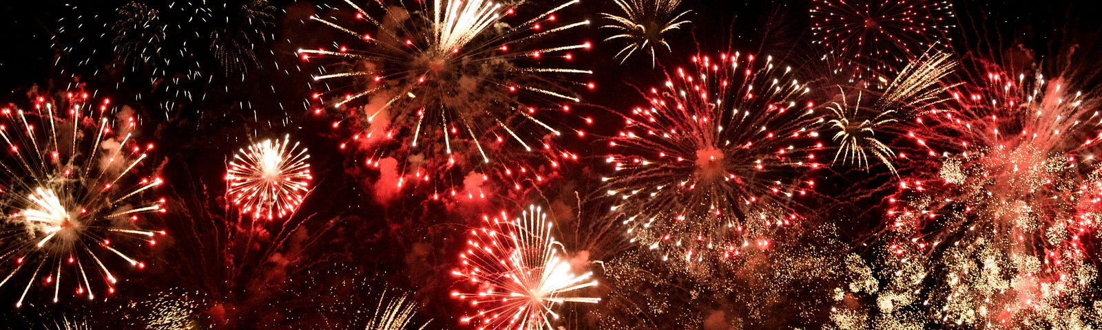 A photo of fireworks that are lighting up the sky in all bright tones.
