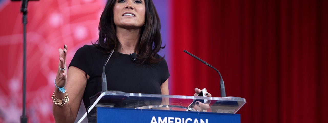 Dana Loesch stands behind a podium labelled American Conservative Union — CPAC
