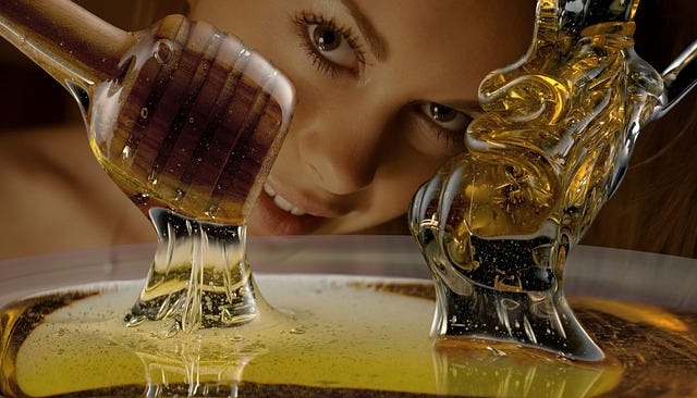 woman’s face watching honey or syrup being drizzled