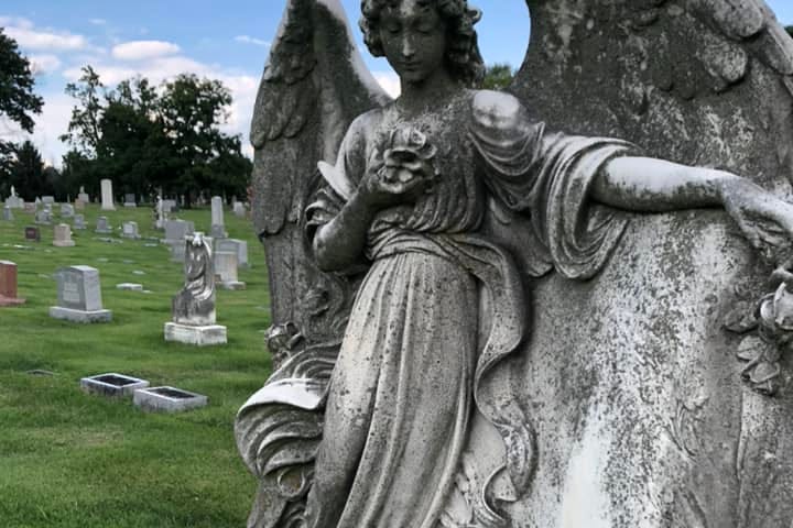 an angel made of cement in a graveyard