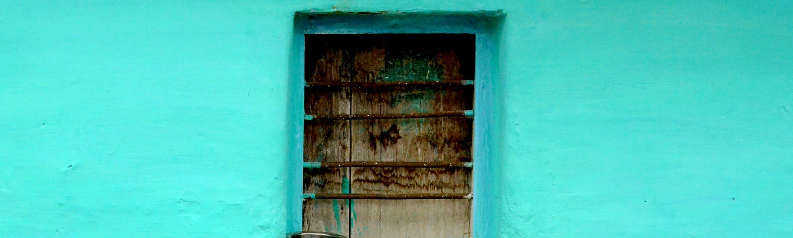 old wooden window in a light blue wall