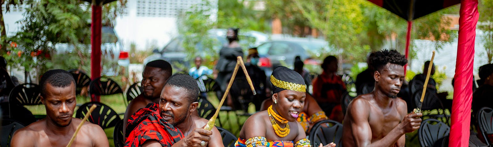 Four Ghanaian adults  drumming