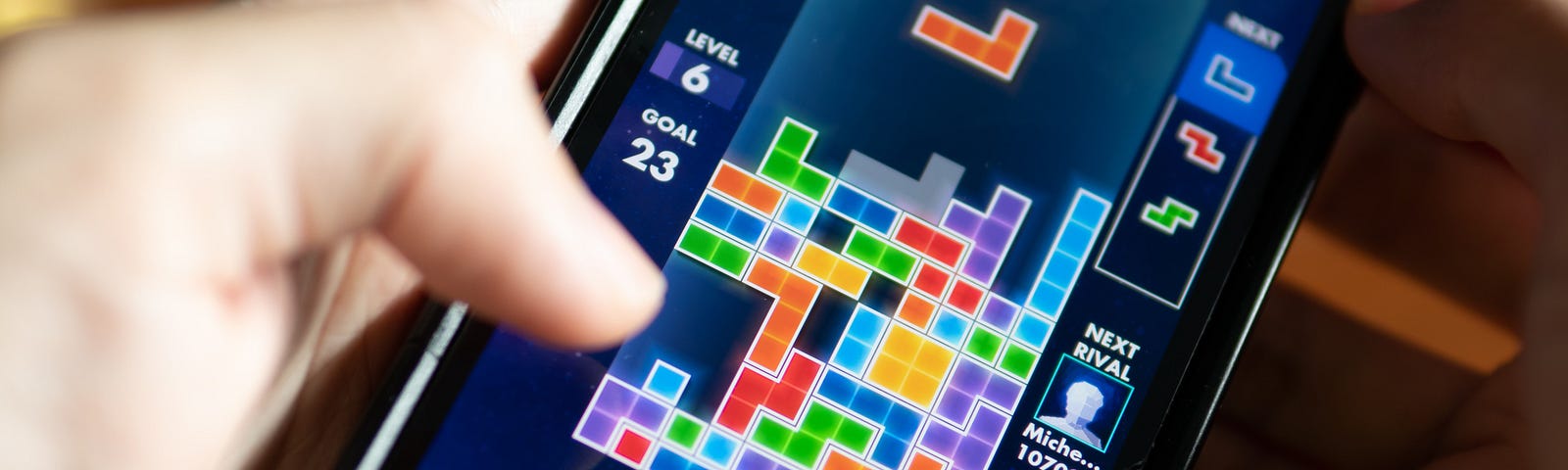 Someone plays Tetris on a mobile device.