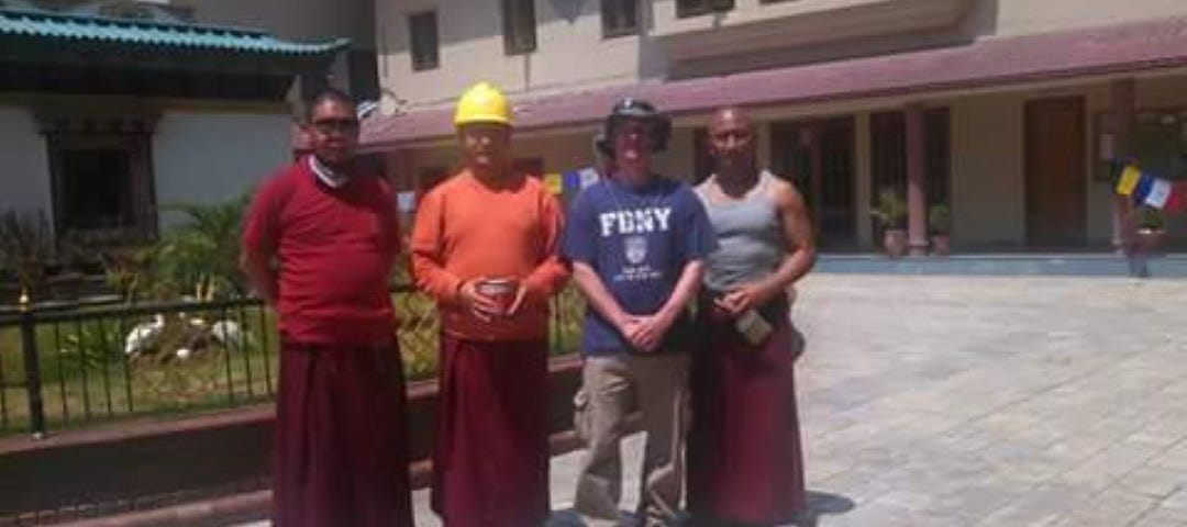 Your author standing in front of the International Buddhist Academy in Kathmandu, Nepal in the days following the 2015 Gorkha Earthquake. Two his left and right are three Tibetan monks.