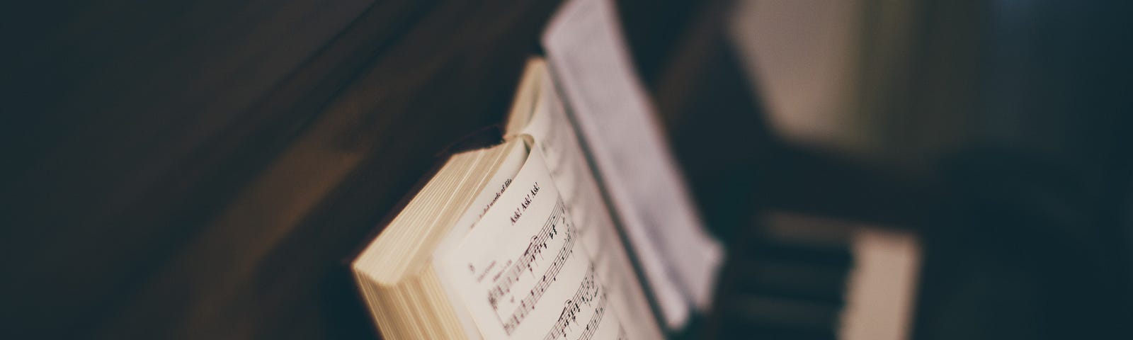 Opened music book on top of a piano