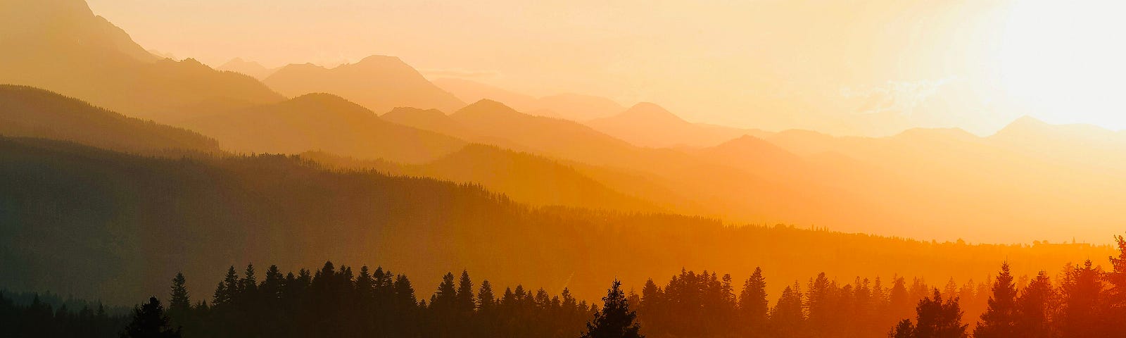 Sunset over layers of mountains and forest