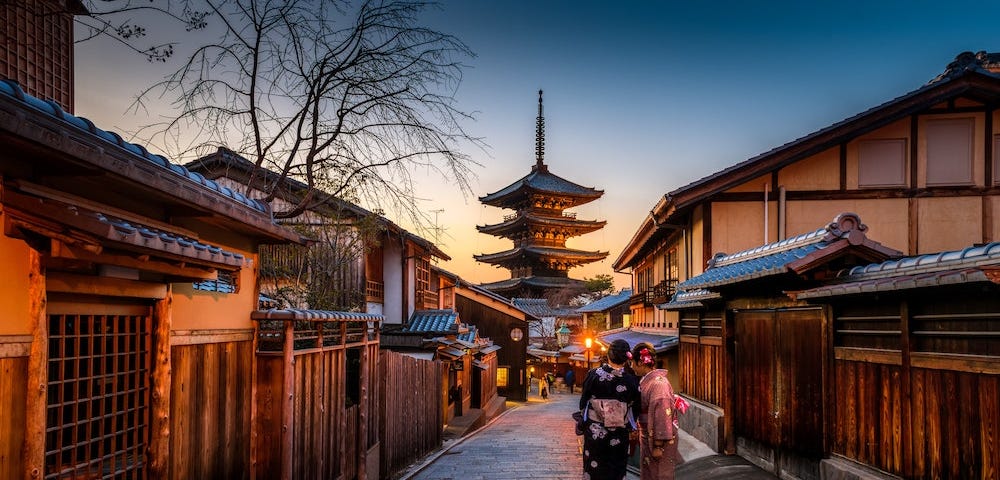 Two female tourists wearing kimono walk towards Kyoto’s Yasaka Pagoda