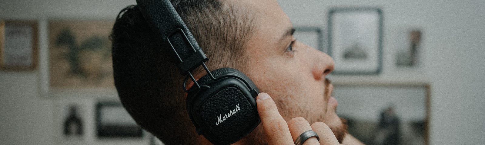 Man looking up while listening to audio on headphones.
