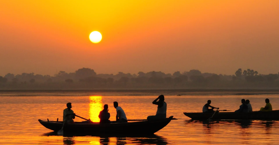people in boats during sunset, golden sky, silhouettes