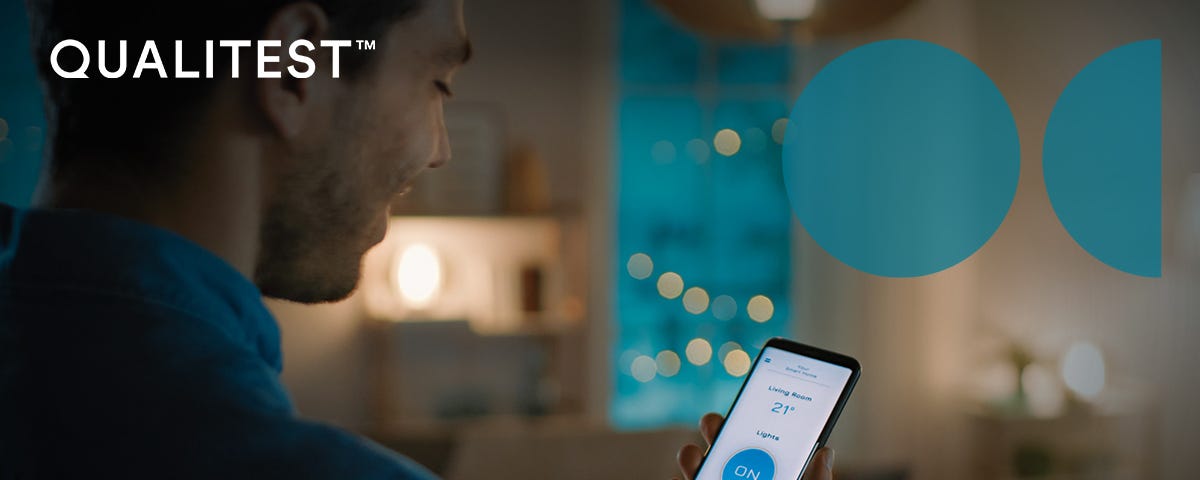 A man controlling the temperature of his home using a smart app on his mobile phone. He’s quietly smiling.