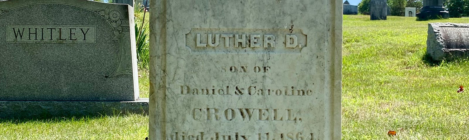 A grave marker reads “Luther D Crowell, son of Daniel & Caroline, died July 11, 1864. Aged 16 years.”