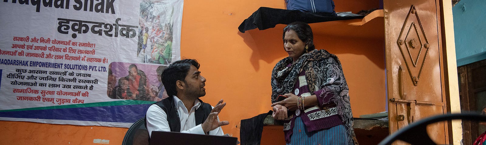 A Haqdarshak team member explains government welfare benefits to an Indian citizen