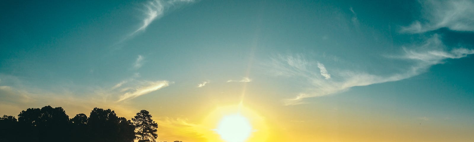 a summer sunset with a beautiful blue sky- just whisps of clouds