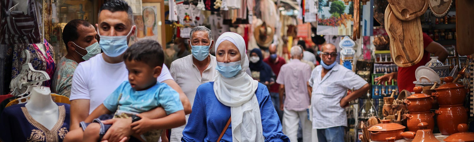 People wearing face masks walk past shops amid the COVID-19 outbreak in the Old City of Tunis, Tunisia, August 3, 2021. Photo by Ammar Awad/Reuters