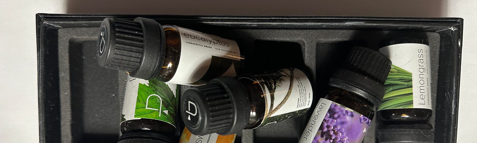A jumble of small bottles of essential oils in a small box