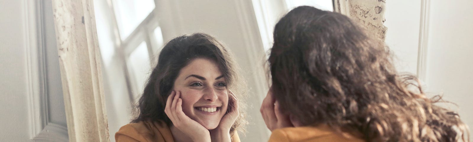 Woman looking into mirror and smiling