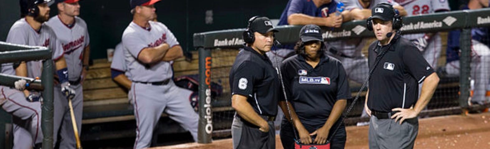 Three umpires on the field wait for results of instant replay review